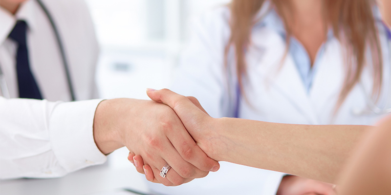 Duas pessoas apertando as mãos firmando um programa de fidelidade na clínica