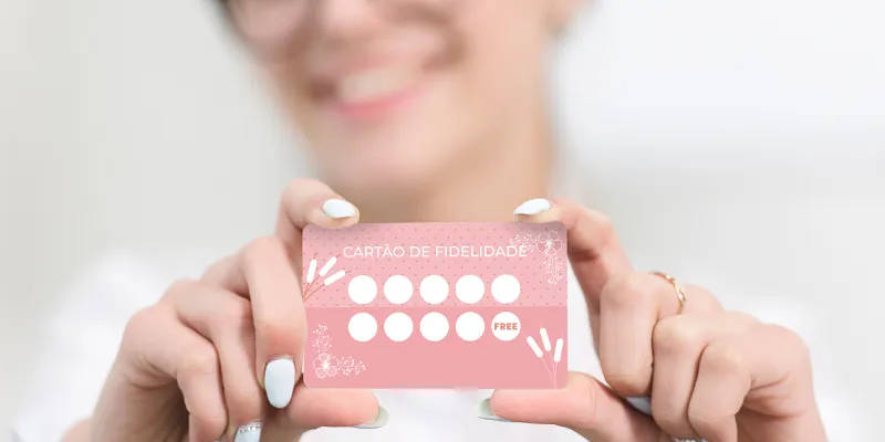 Mulher mostrando o cartão do programa de benefícios para clientes